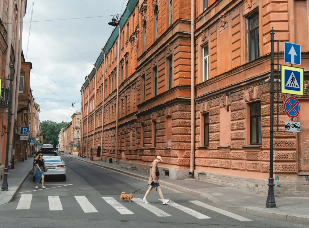 A person crossing a street in front of a building